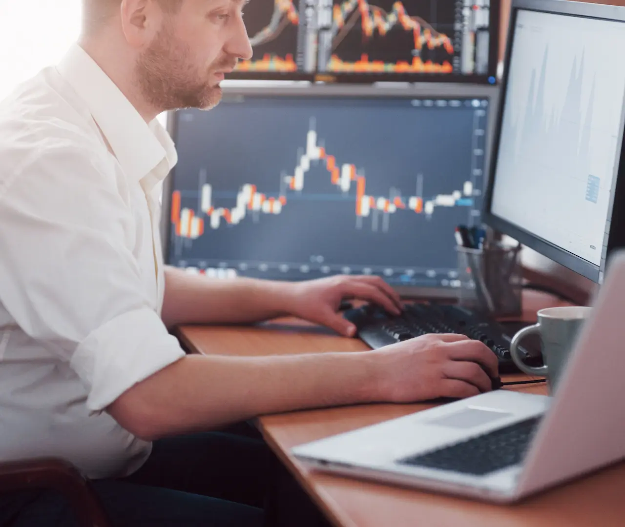 male_investor_monitoring_market_performance_on_laptop_lqhmarkets