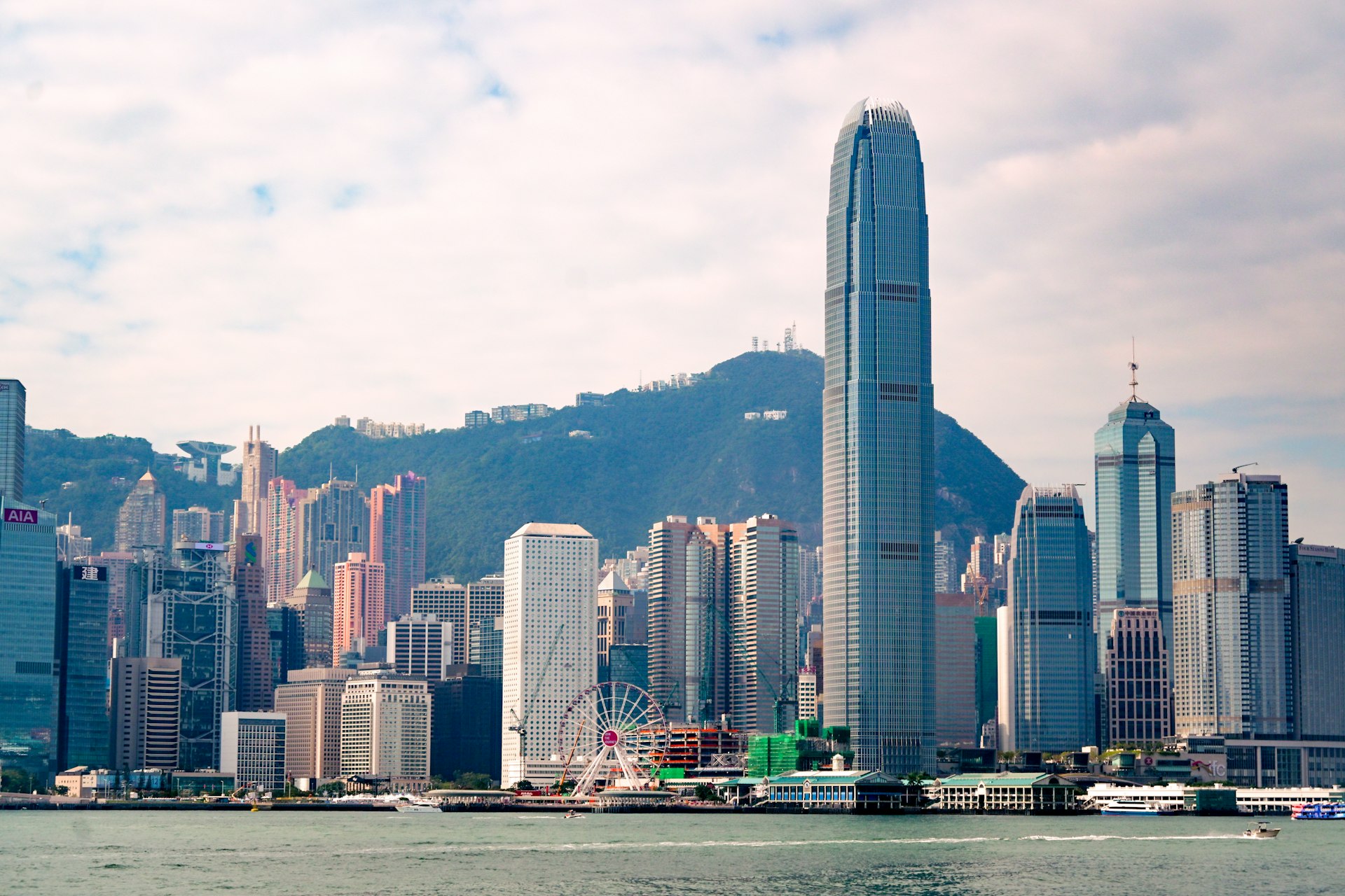 Night view of Hong Kong's illuminated financial district skyline with high-rise office towers along the harbour